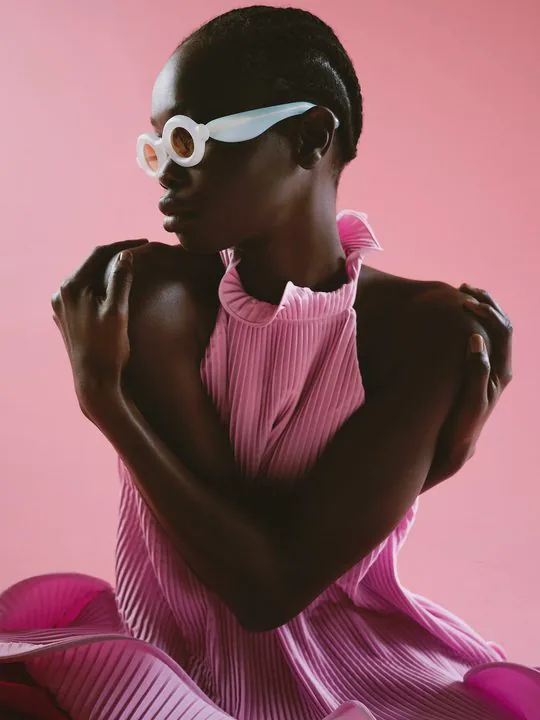 Paloceras eyewear editorial — model in pink pleats on a pink backdrop